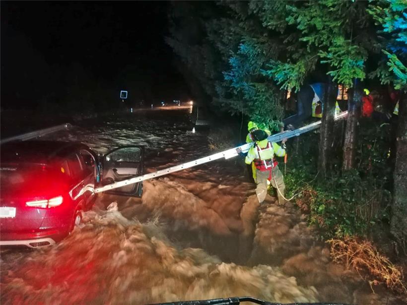 Feuerwehrleute hantieren mit einer Leiter an einem Auto, dass an der zu einem reißenden Strom angeschwollenen Pilach steht. Aufgrund der starken Niederschläge ist Sonntagfrüh ganz Niederösterreich zum Katastrophengebiet erklärt worden.
