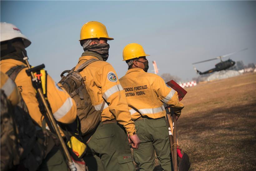 Feuerwehrleute stehen bereit, um in das Brandgebiet gebracht zu werden
