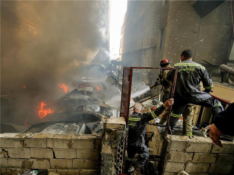Feuerwehrleute löschen Brand nach israelischem Luftangriff in Beirut, Einsatz in beschädigtem Stadtgebiet bei Nacht