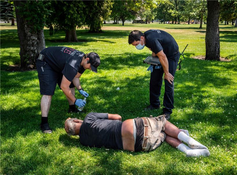 Feuerwehrmann Sean Condon und Leutnant Gabe Mills überprüfen das Wohlergehen eines Mannes
