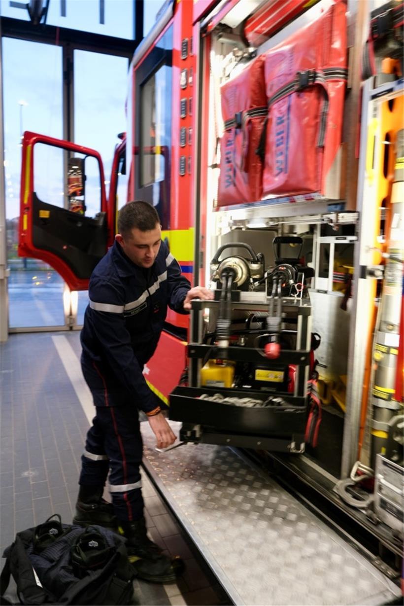 Feuerwehrmann überprüft vor Nachteinsatz Funkgeräte und Atemschutzgerät für sicheren Materialcheck
