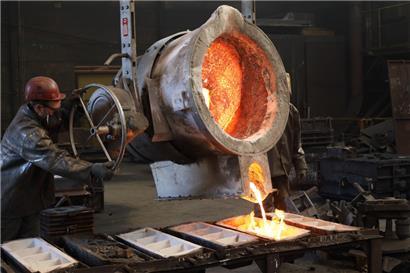 Feuriger Job: Arbeiter schütten die Reste aus der Gießpfanne 
