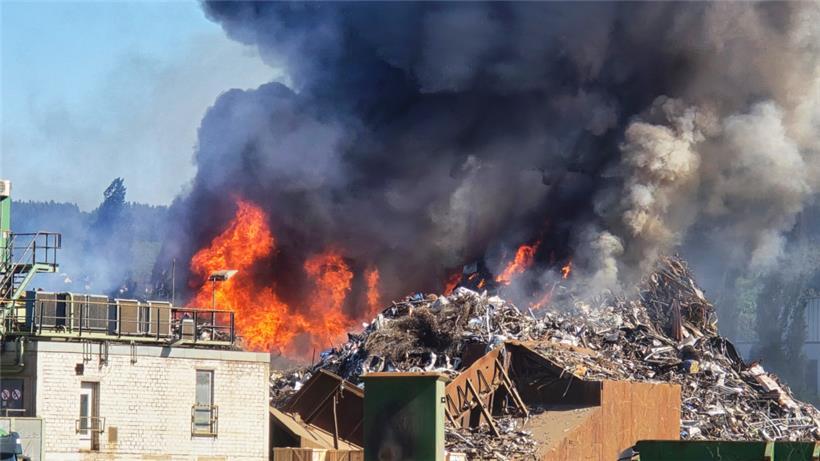 Flammen und Rauch schlagen aus einem Berg von Metallschrott im Trierer Industriehafen
