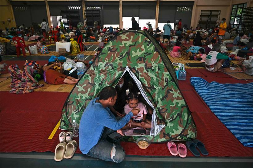 Flüchtlinge essen Frühstück, während sie in einer Turnhalle auf dem Gelände der Surindra Rajabhat University in der thailändischen Grenzprovinz Surin Schutz suchen. Mehr als 100.000 Menschen sind laut Angaben aus Bangkok vom 25. Juli vor den blutigsten Grenzkämpfen zwischen Thailand und Kambodscha seit einem Jahrzehnt geflohen
