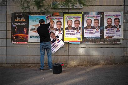 Franck Othmame Gord, organisateur de la campagne „La France Insoumise“, accroche des affiches électorales à Marseille
