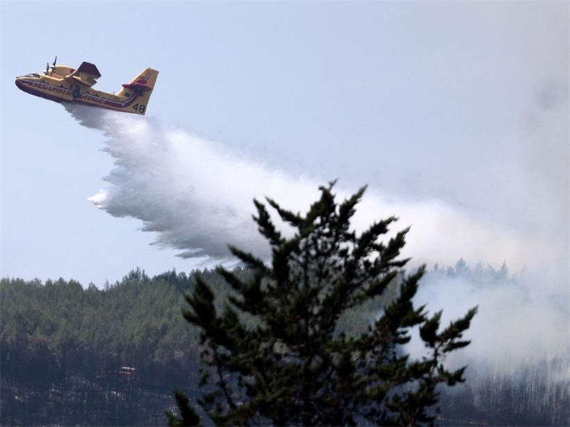 Frankreich, Taradeau: Ein Flugzeug des französischen Zivilschutzes vom Typ Canadair CL-415 besprüht einen Wald mit Wasser, nachdem im Département Var in der Region Provence-Alpes-Côte d’Azur im Südosten Frankreichs ein Waldbrand ausgebrochen war