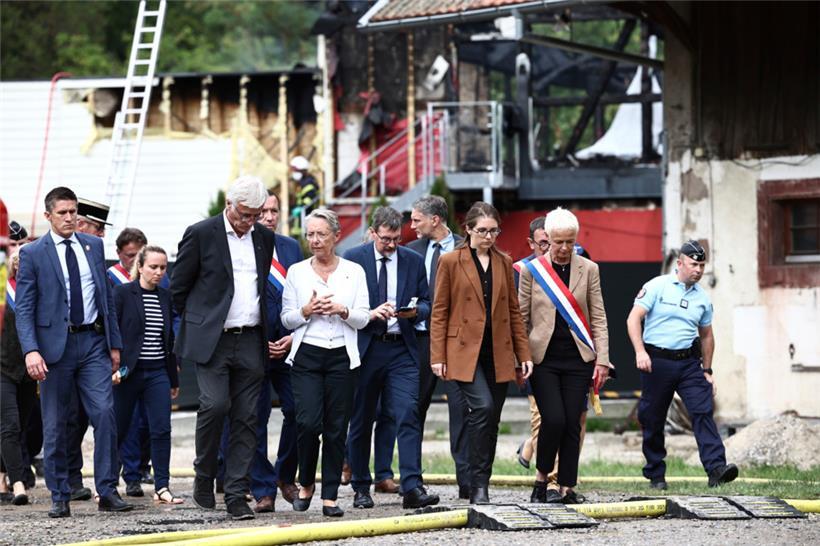 Frankreich, Wintzenheim: Elisabeth Borne (Mitte l), Ministerpräsidentin von Frankreich, spricht mit Beamten. Bei dem tödlichen Feuer in einer Ferienunterkunft im Elsass vermutet die Justiz einen Schwelbrand.
