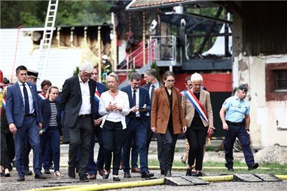 Frankreich, Wintzenheim: Elisabeth Borne (Mitte l), Ministerpräsidentin von Frankreich, spricht mit Beamten. Bei dem tödlichen Feuer in einer Ferienunterkunft im Elsass vermutet die Justiz einen Schwelbrand.
