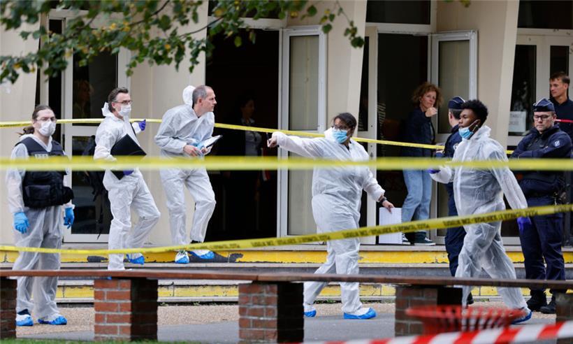 Französische Polizeibeamte des forensischen Dienstes stehen in Arras vor dem Gymnasium, nachdem ein Messerangreifer einen Menschen getötet und mehrere verletzt hat. 
