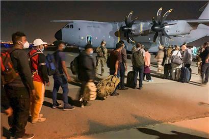 Französische und afghanische Staatsangehörige stehen am 17. August 2021 auf dem Flughafen von Kabul an, um ein französisches Militärtransportflugzeug zu besteigen, mit dem sie nach der überraschenden militärischen Übernahme des Landes durch die Taliban aus Afghanistan evakuiert werden sollen.
