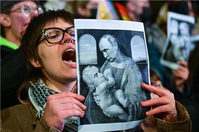Frei nach Da Vincis „Madonna mit Kind“, Kremlherrscher Wladimir Putin mit dem prorussischen rumänischen Präsidentschaftskandidaten Calin Georgescu im Arm. Das Bild wird während eines Protestes gegen den prorussischen Kandidaten gezeigt
