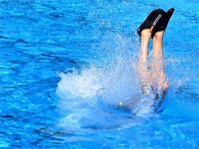Freibad mit Schwimmern und Sonnenschein zur Abkühlung bei heißer Hitzewelle im Sommer