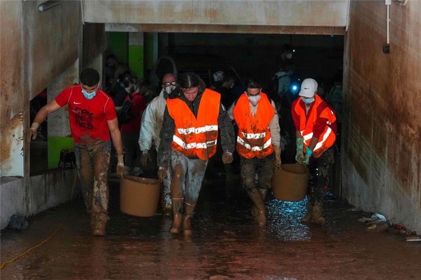 Freiwillige tragen Schlamm aus einer Tiefgarage in Aldaia in der Region Valencia
