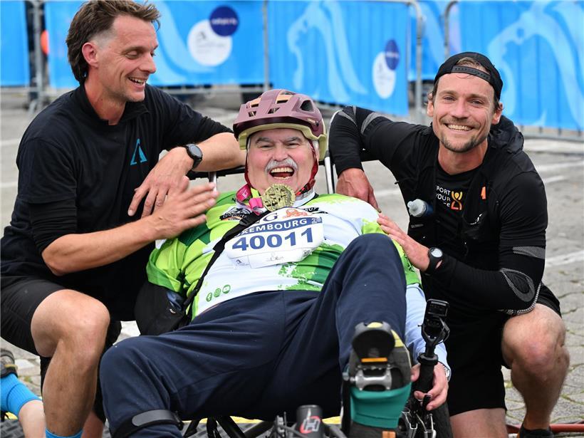 Freudige Person hält Medaille auf dem Glacis bei sonnigem Wetter, Feier und Erfolg im Freien