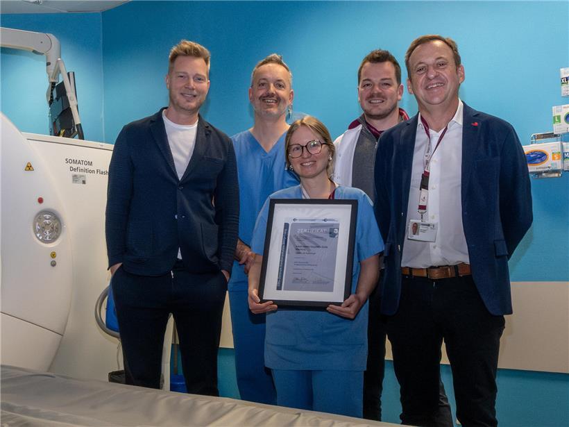 Mann freut sich über erfolgreiche Zertifizierung mit Urkunde in hellem Büro, Symbol für beruflichen Erfolg