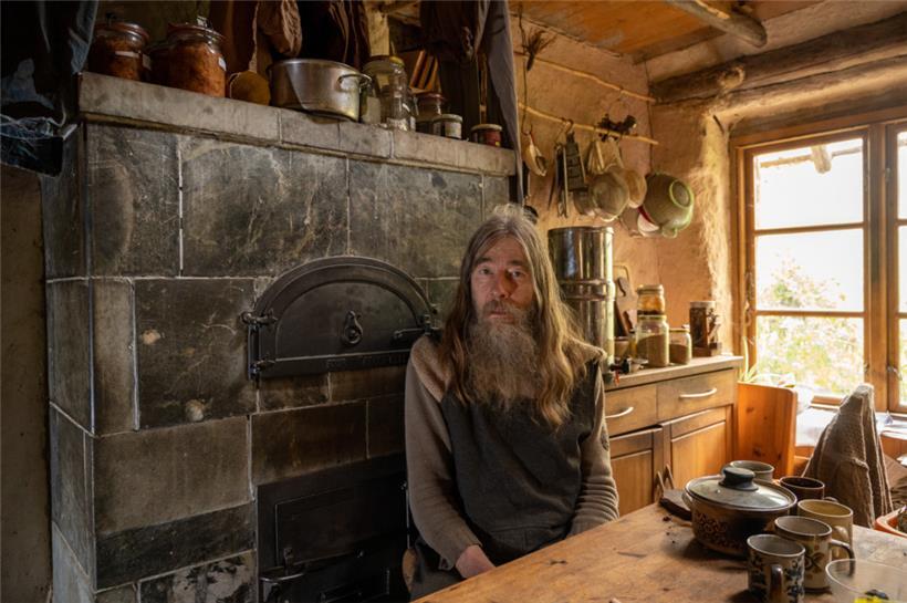 Friedmunt Sonnemann sitzt in der Küche seines Lehmhauses
