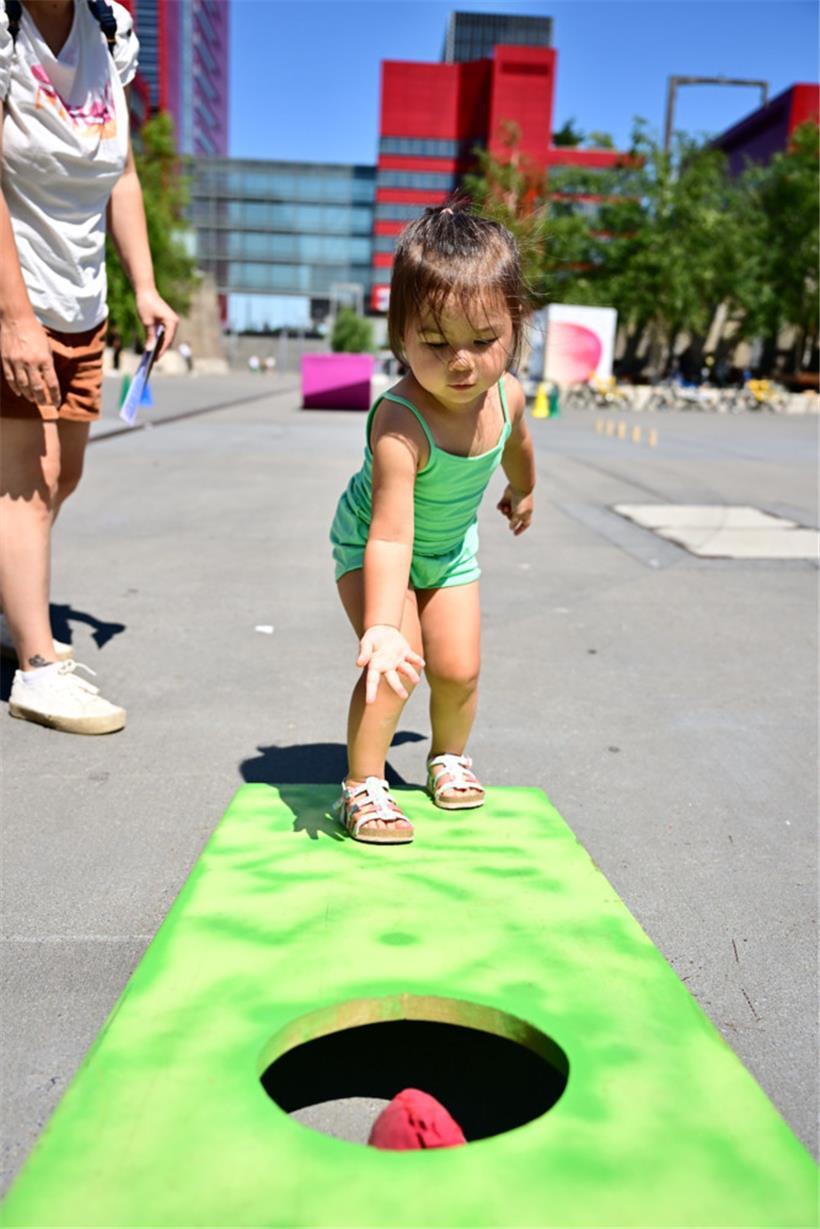 Für Fahrradfahren ist Robynn noch zu klein, deshalb übt sie sich im Spiel „Cornhole“
