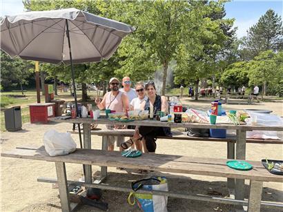 Susana rechts im Sanemer Galgenberg Park, umgeben von grünen Bäumen und blühenden Pflanzen an sonnigem Tag