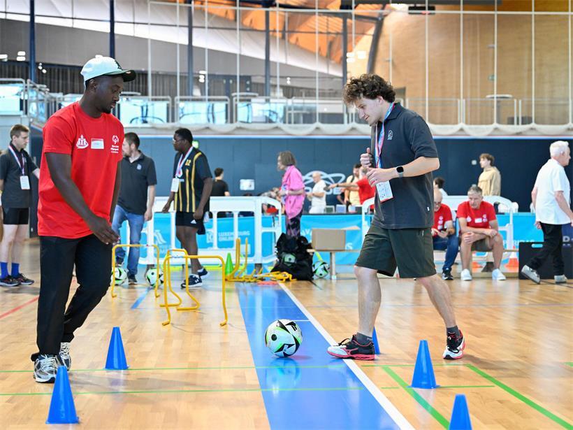 Fußballspieler beim Dribbling-Parcours mit Ball, Geschicklichkeit und Technik auf dem Sportplatz