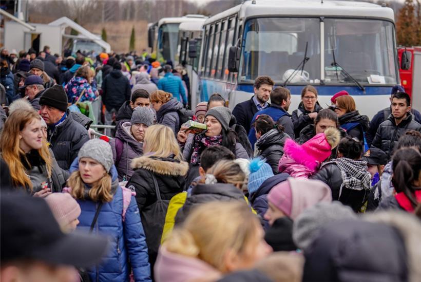 Geflüchtete warten am Freitag, 4.3., vor der Flüchtlingssammelstelle im polnischen Mlyny, einem ehemaligen Einkaufszentrum, nur wenige Kilometer von der ukrainisch-polnischen Grenze in Korczowa entfernt, auf die Weiterfahrt in Bussen in eine andere Stadt. 
