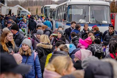 Geflüchtete warten am Freitag, 4.3., vor der Flüchtlingssammelstelle im polnischen Mlyny, einem ehemaligen Einkaufszentrum, nur wenige Kilometer von der ukrainisch-polnischen Grenze in Korczowa entfernt, auf die Weiterfahrt in Bussen in eine andere Stadt. 

