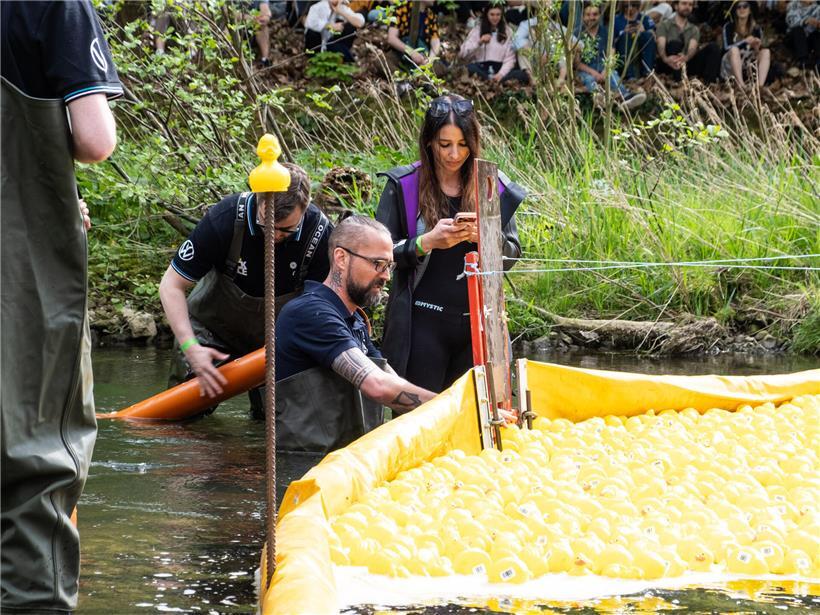 Gewinnerenten werden gemeinsam mit Notarin aus dem Wasser gezogen bei traditionellem Entenrennen Event