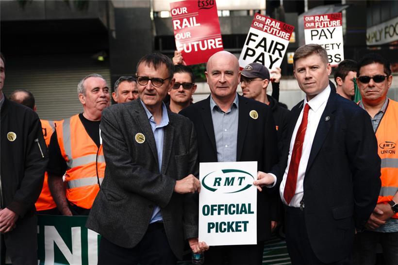 Generalsekretär Mick Lynch (M.) und Eddie Dempsey (r.), stellvertretender Generalsekretär der Gewerkschaft Rail, Maritime and Transport (RMT), stehen vor dem Londoner Bahnhof Euston, an einem Streiktag der Gewerkschaft
