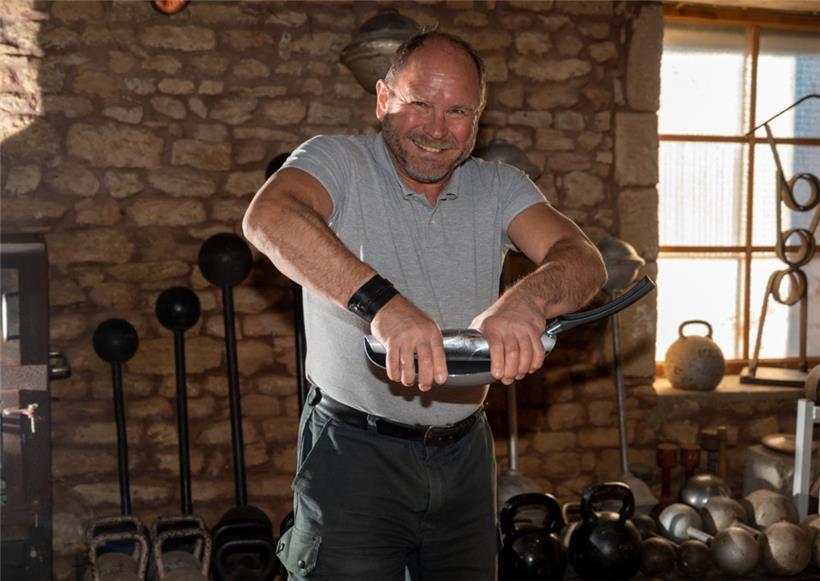 Georges Christen rollt mit blossen Händen in seiner Trainingsscheune eine handelsübliche Bratpfanne zusammen
