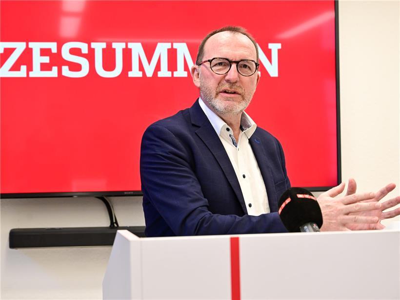 Georges Engel spricht bei einer Pressekonferenz vor Mikrofonen und Medienvertretern.