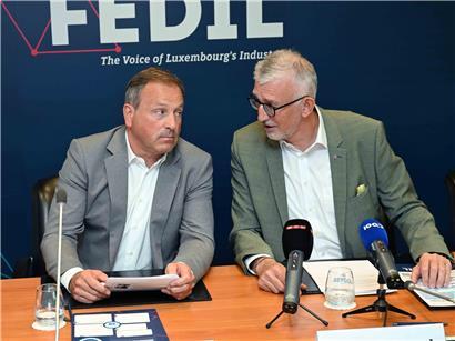 Alex Schumann und Georges Rassel bei einer beruflichen Veranstaltung, Porträt von zwei Geschäftsmännern in Anzügen