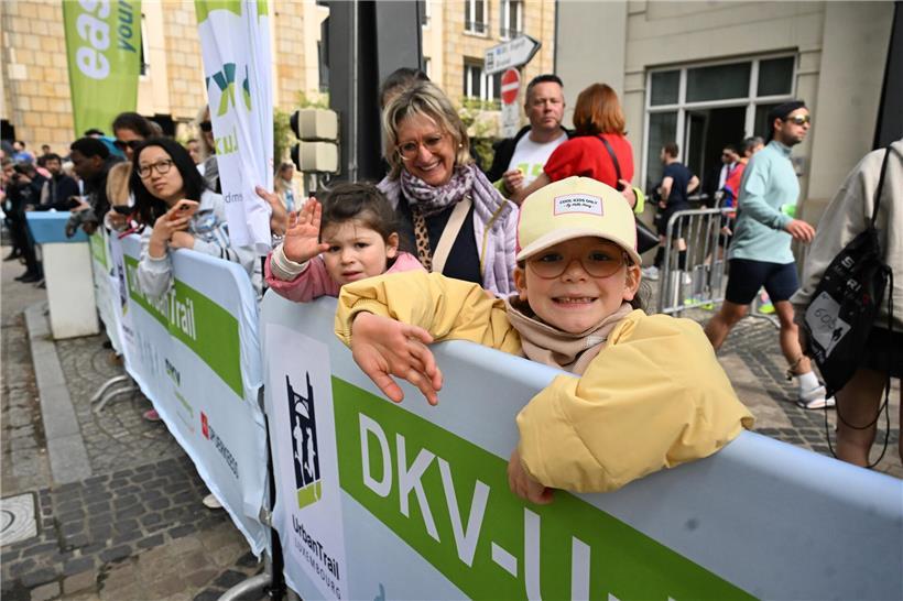 Gespannt wartende Menschen im Zielbereich eines Sportevents bei sonnigem Wetter