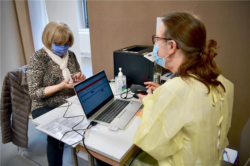 Gespräch vor der Impfung: Frau W. hat eine Liste mit allen Medikamenten dabei, d...