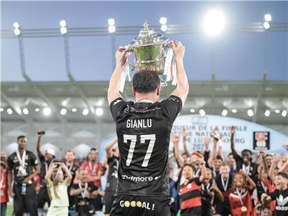 Gianluca Bei hält strahlend seine letzte Fußball-Trophäe zum Karriereende in die Höhe