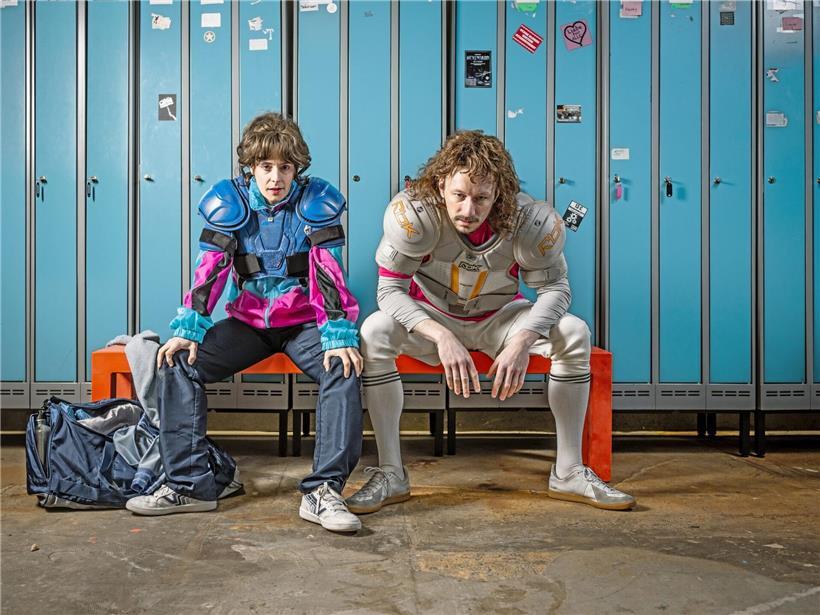 Brigitte Urhausen und Daniel Mutlu posieren gemeinsam als Schauspielkollegen vor neutralem Hintergrund