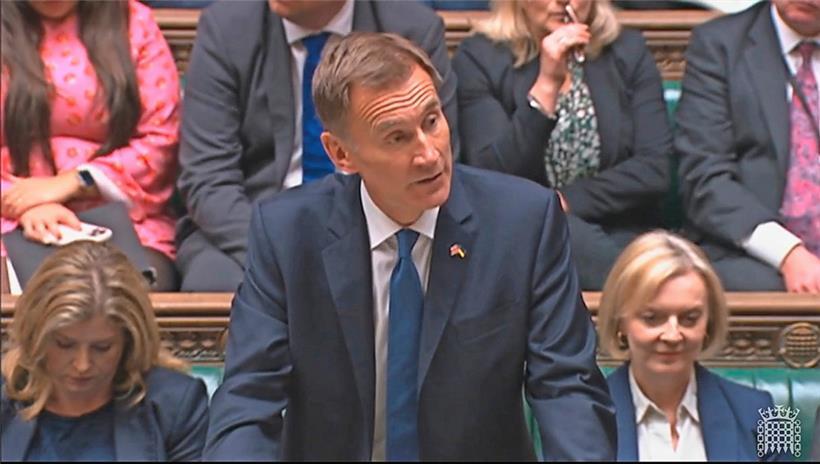 Großbritanniens neuer Finanzminister Jeremy Hunt (M.) spricht im britischen Unterhaus, während (Noch-)Premierministerin Liz Truss (r.) hinter ihm zuhört
