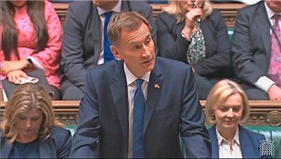 Großbritanniens neuer Finanzminister Jeremy Hunt (M.) spricht im britischen Unterhaus, während (Noch-)Premierministerin Liz Truss (r.) hinter ihm zuhört
