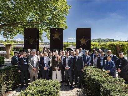 Gruppenbild vor dem Schengener Grenzübergang mit Menschen verschiedener Nationalitäten im Freien