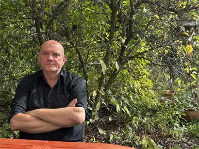 Guy Helminger in seinem Garten in Köln