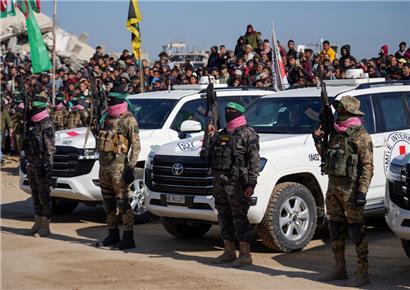 Hamas-Kämpfer beziehen Stellung vor Autos des Internationalen Roten Kreuzes
