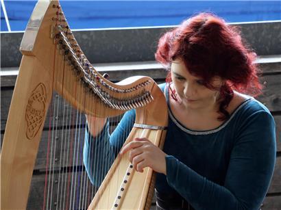 Harfenistin spielt sanfte Harfenmusik beim traditionellen Bealtaine-Festival im Freien