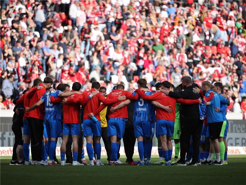 Heidenheims Fußballspieler stehen eng beieinander mit dem Rücken zur Wand in einer angespannten Spielsituation