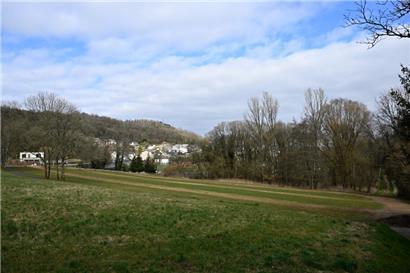 Hier sollen Hotel und Wellnessoase gebaut werden. Hinter den Bäumen befindet sich das kommunale Schwimmbad, die Häuser gehören zur Gemeinde Petingen.  
