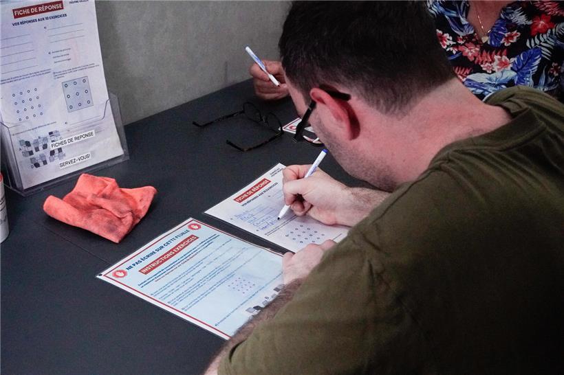 Mann schwitzt und wirkt konzentriert, Hitze beeinträchtigt geistige Leistungsfähigkeit und Konzentration deutlich