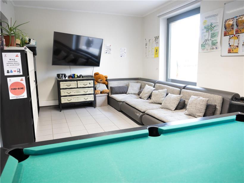 Jugendliche kochen und unterhalten sich gemeinsam im Jugendhaus – entspannte Atmosphäre für soziale Begegnungen und Gemeinschaft.