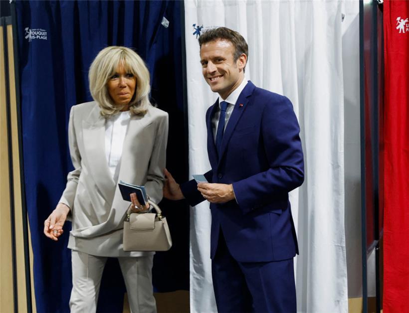 Im Kasten: Emmanuel Macron, Präsident von Frankreich, und seine Frau Brigitte Macron verlassen die Wahlkabine in einem Wahllokal
