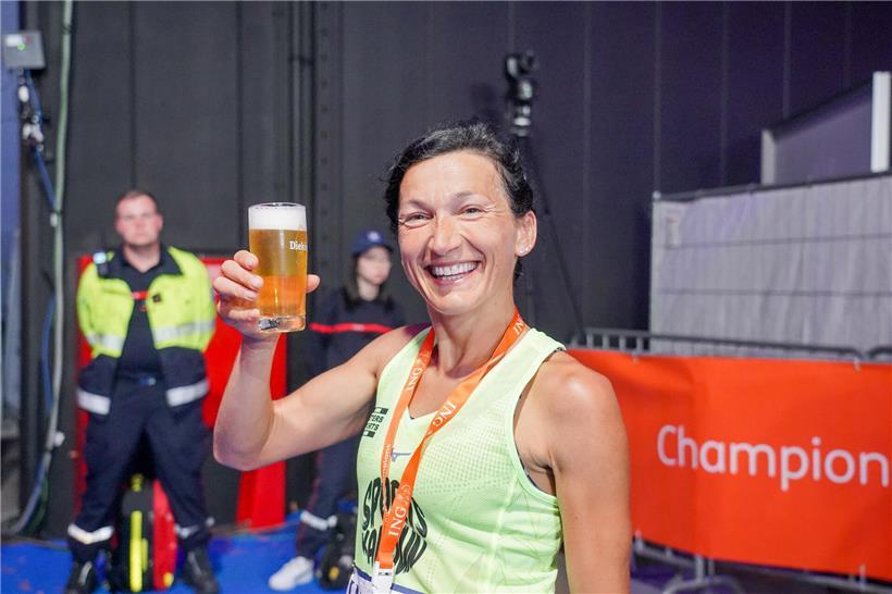 Ultra-Strecken-Läuferin feiert im Ziel mit Belohnung nach anspruchsvollem Ultra-Marathon