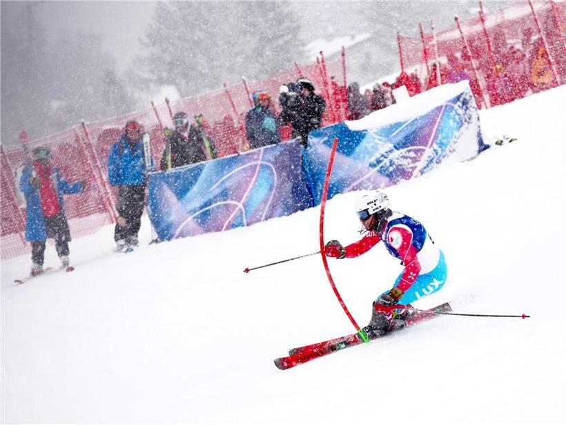 Athleten kämpfen bei starkem Schneefall im ersten Durchgang eines Wintersportwettkampfs