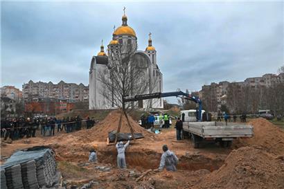 Im ukrainischen Ort Butscha wird ein Massengrab untersucht
