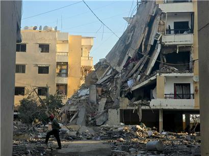 Anwohner in Beirut geht nachts nach israelischem Luftangriff an zerstörtem Gebäude im Libanon vorbei