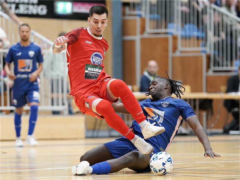 Zwei Fußballspieler in Düdelingen kämpfen intensiv um den Ball in einem spannenden Match voller Zweikämpfe.